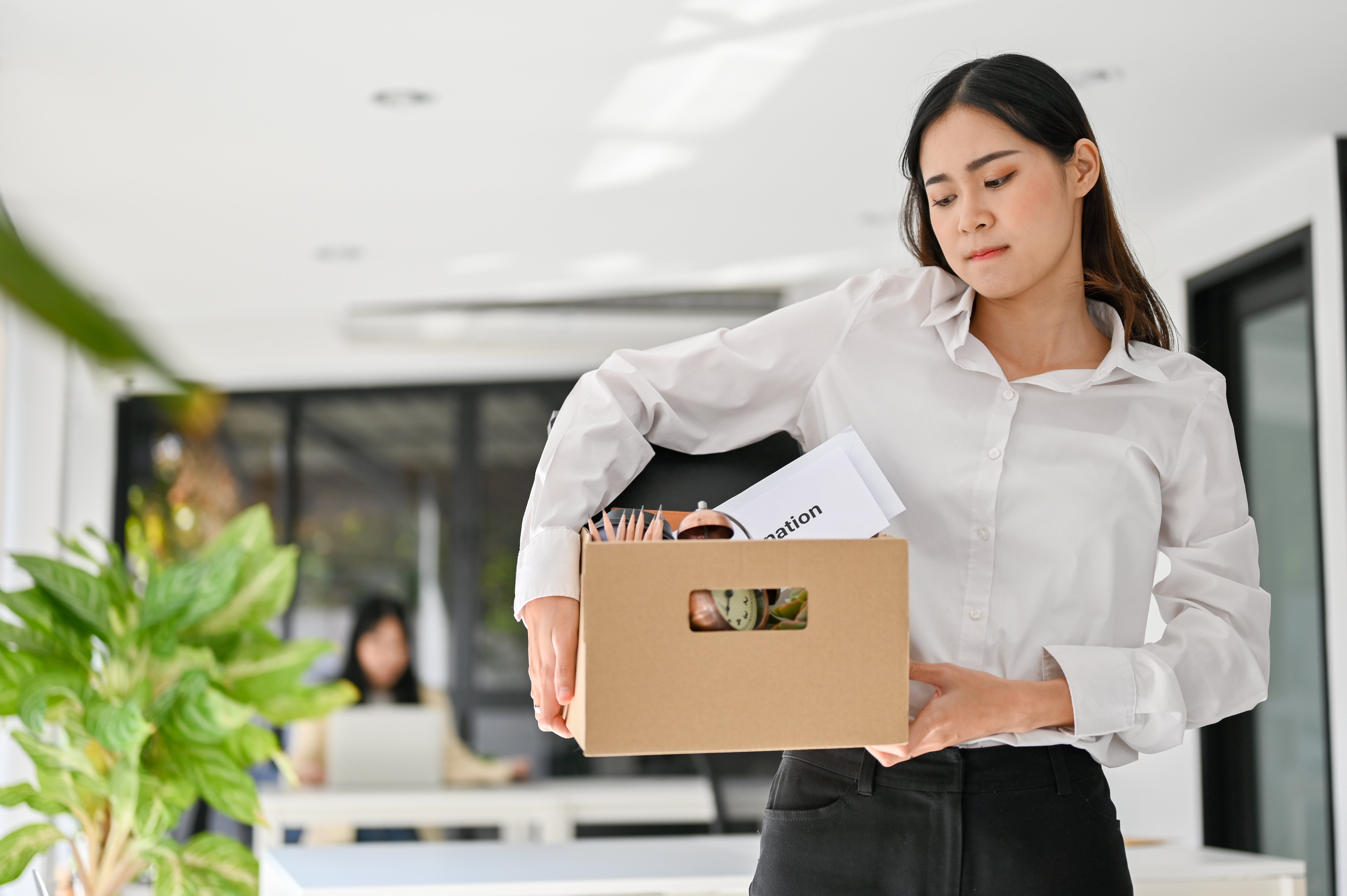 sad-asian-female-office-worker-carrying-her-belonging-quitting-job-being-fired-from-her-boss